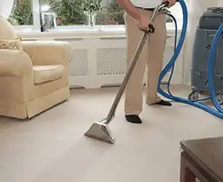 Carpet cleaning professional removing dirt and stains with a hot-water extraction tool in a home, Pueblo, CO.